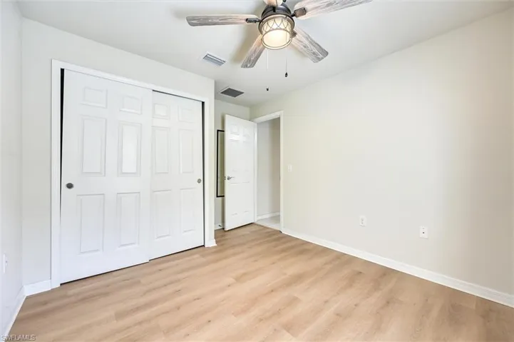 Unfurnished bedroom with light wood-type flooring, a ceiling fan, and a closet