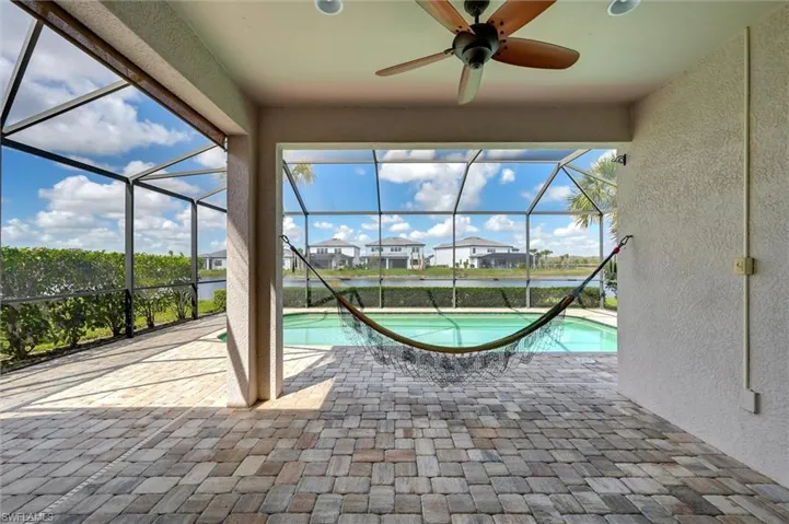 Swimming pool with a sunroom, a residential view, a patio area, and a lanai