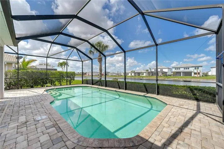 Swimming pool featuring a residential view, a sunroom, a patio, and a lanai
