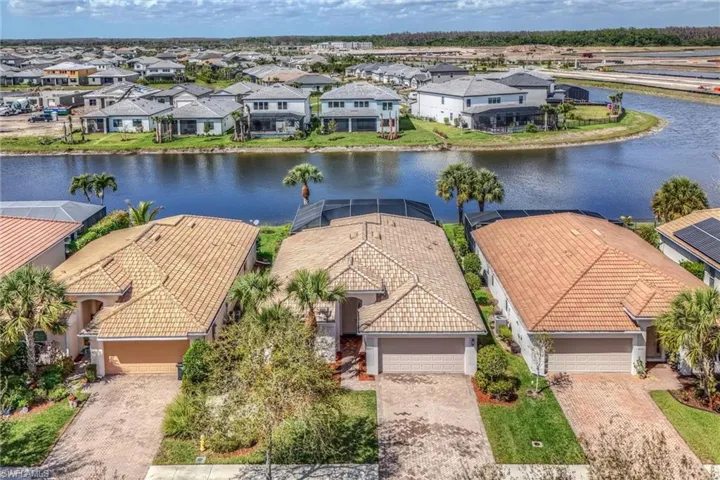 Aerial perspective of suburban area featuring a nearby body of water