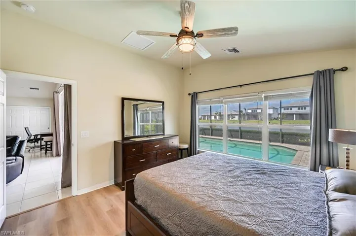Bedroom with light wood-style flooring, access to exterior, ceiling fan, and vaulted ceiling
