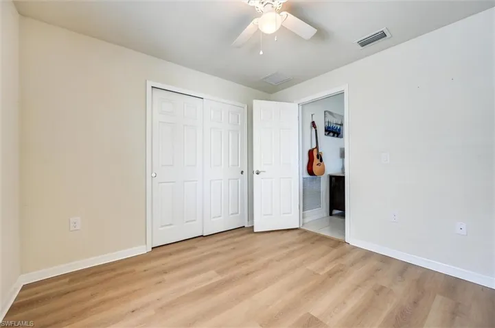 Unfurnished bedroom with light wood finished floors, ceiling fan, and a closet