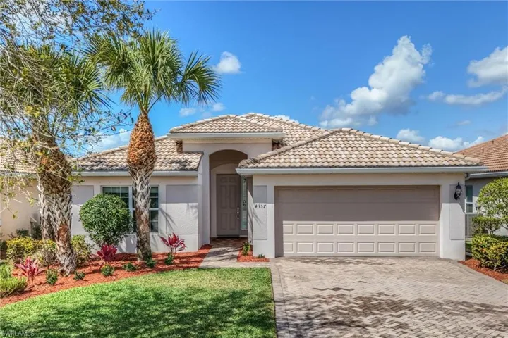 Mediterranean / spanish home featuring a garage, decorative driveway, stucco siding, and a front lawn