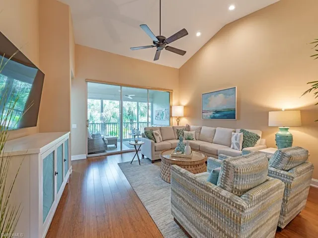 Living room featuring high vaulted ceiling, ceiling fan, and hardwood / wood-style floors