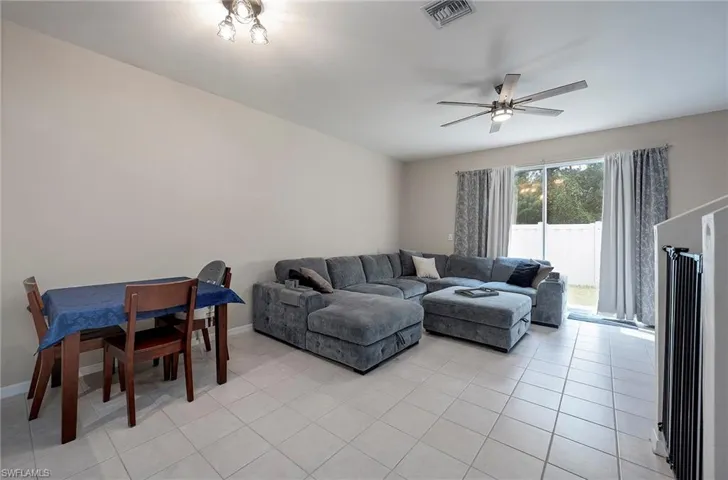 Living room with light tile patterned floors and ceiling fan
