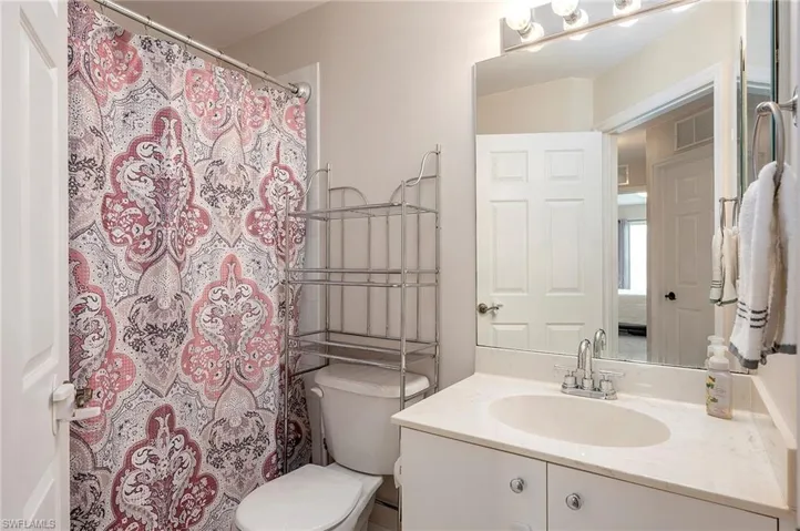 Bathroom with walk in shower, vanity, and toilet