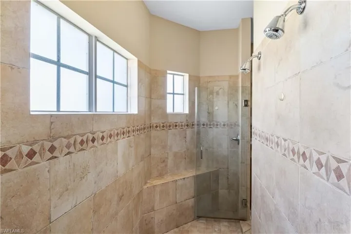 Bathroom with a tile shower and tile walls