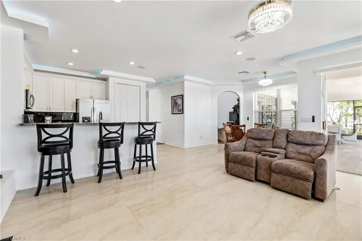 Living area with recessed lighting, crown molding, and arched walkways