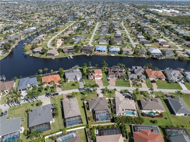 Aerial view of property and surrounding area featuring a large body of water and nearby suburban area