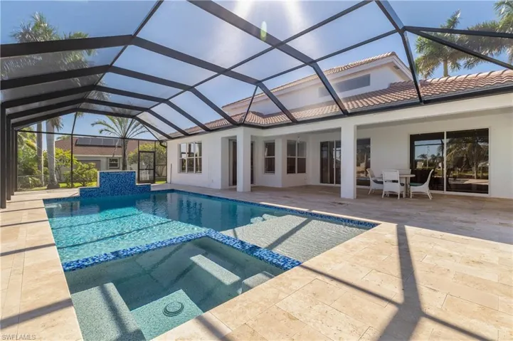 View of pool featuring a sunroom, a pool with connected hot tub, and a lanai