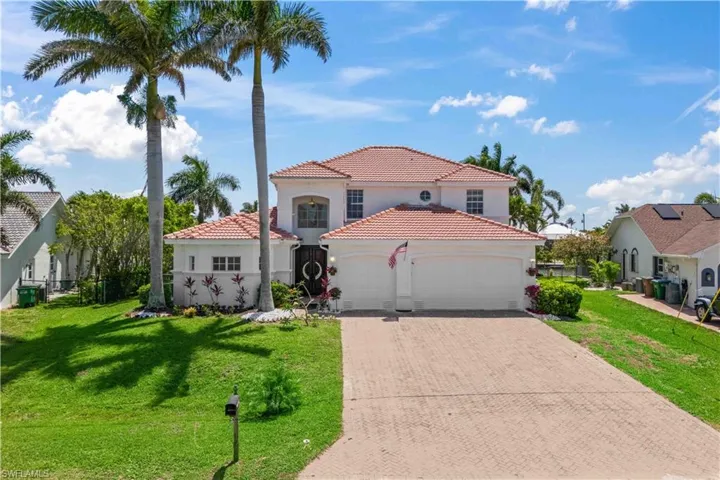 Mediterranean / spanish house featuring an attached garage, decorative driveway, stucco siding, and a tiled roof