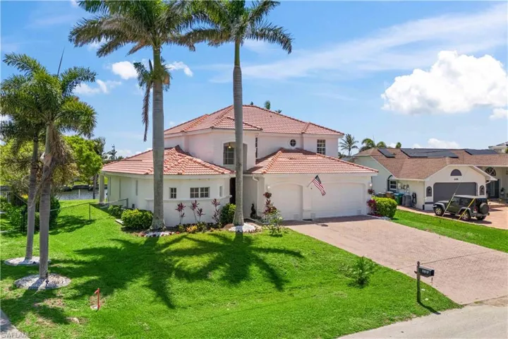 Mediterranean / spanish-style home featuring a garage, driveway, a tiled roof, stucco siding, and a front lawn
