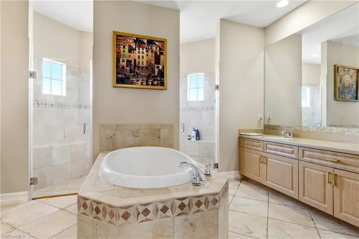 Full bath featuring a bath, vanity, and a shower stall