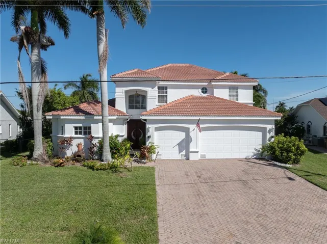 Mediterranean / spanish home with a front lawn, an attached garage, and stucco siding