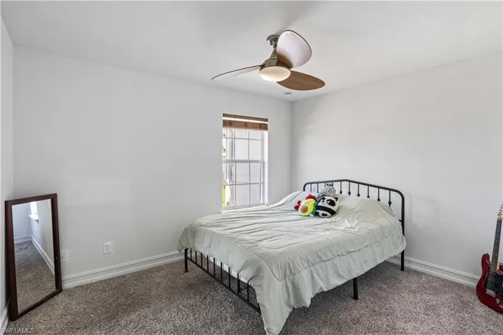 Bedroom with carpet floors, baseboards, and a ceiling fan