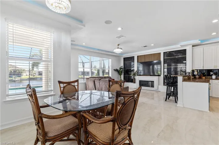 Dining space with a glass covered fireplace and recessed lighting