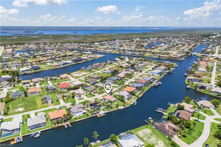 Aerial view of property and surrounding area with nearby suburban area and a large body of water