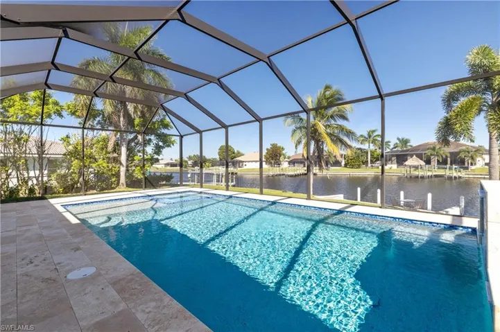 Outdoor pool with a water view, a sunroom, a lanai, and a dock