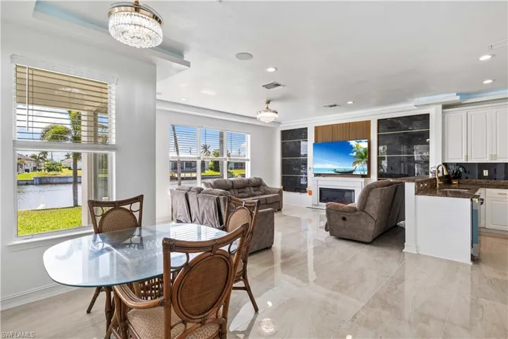 Dining room featuring recessed lighting, a chandelier, a glass covered fireplace, and a water view