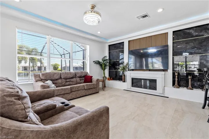 Living room featuring a glass covered fireplace and recessed lighting