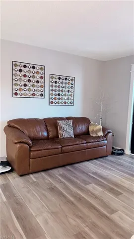 Living area featuring light wood finished floors and a textured ceiling