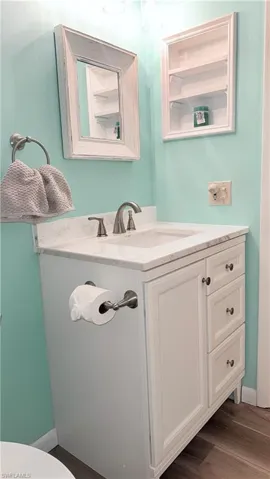 Half bathroom with vanity and dark wood-style flooring