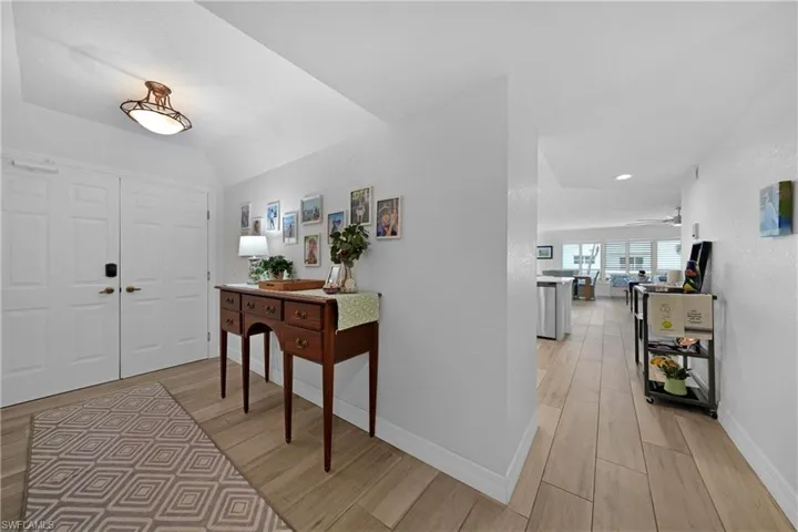 Foyer with light hardwood / wood-style floors, ceiling fan, and lofted ceiling