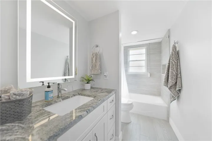 Full bathroom with vanity, toilet, and shower / bath combo with shower curtain