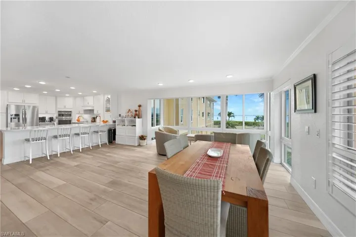 Dining space with light hardwood / wood-style flooring and ornamental molding