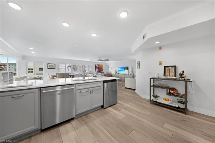 Kitchen with ceiling fan, dishwasher, ornamental molding, and sink