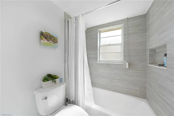 Bathroom with shower / tub combo with curtain and toilet