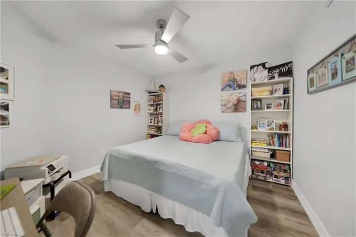 Bedroom with ceiling fan and hardwood / wood-style flooring