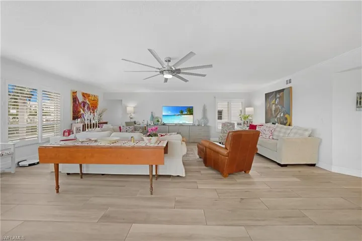 Living room with ceiling fan and ornamental molding