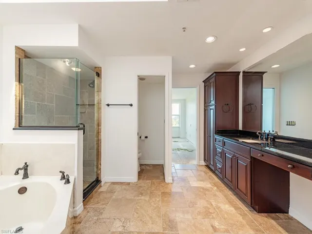 Full bathroom with vanity, tile patterned floors, shower with separate bathtub, and toilet