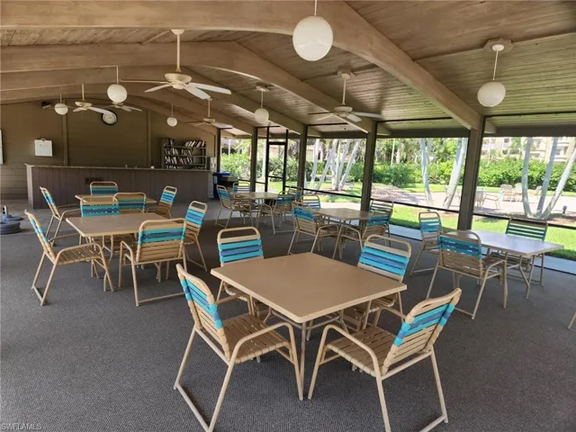 Carpeted dining space featuring ceiling fan, lofted ceiling with beams, and wooden ceiling