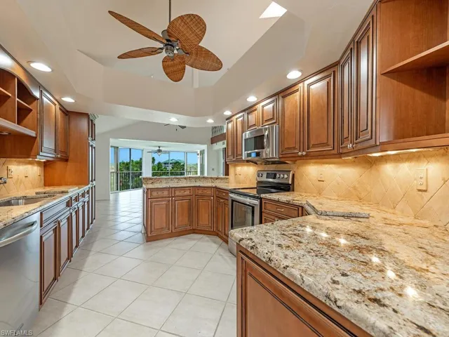 Kitchen with tasteful backsplash, kitchen peninsula, appliances with stainless steel finishes, and ceiling fan