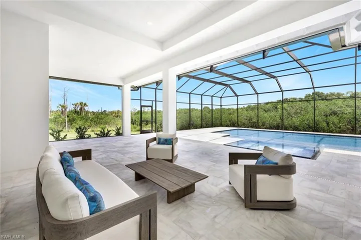 Swimming pool with an outdoor living space, a patio area, and a lanai