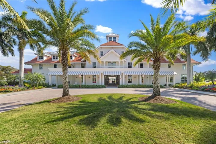View of front facade with curved driveway and a front yard