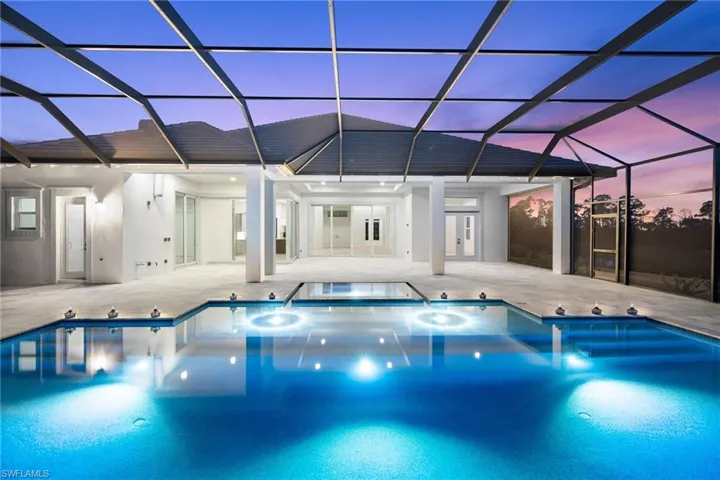 Pool at dusk featuring an outdoor pool, a patio area, and a lanai