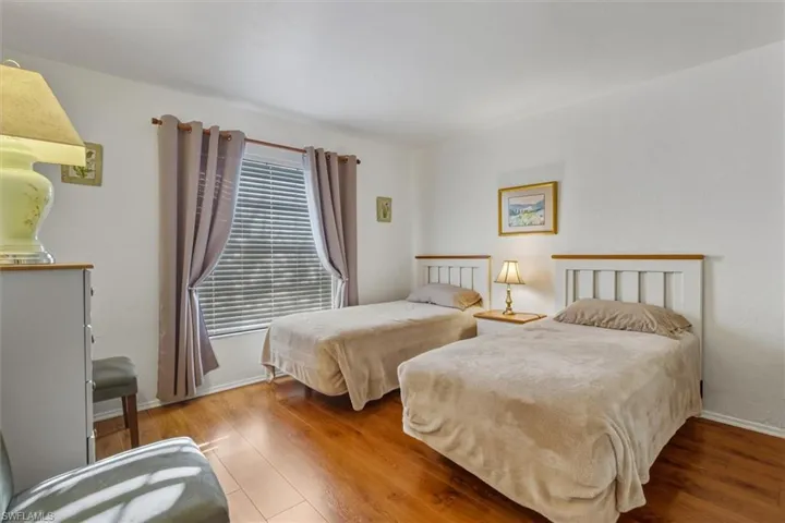 Bedroom featuring hardwood / wood-style flooring and baseboards