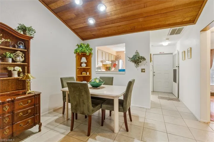Dining area featuring light tile patterned floors, recessed lighting, and wooden ceiling