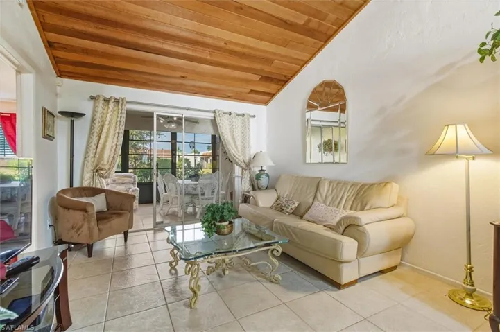 Living area featuring wooden ceiling, lofted ceiling, and light tile patterned flooring