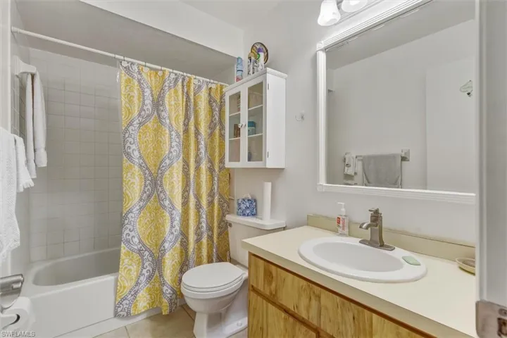 Full bath with shower / tub combo, vanity, and light tile patterned floors
