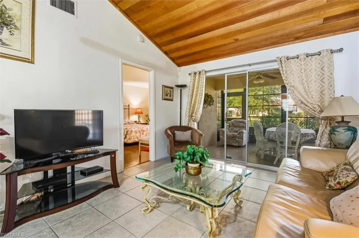 Tiled living area with wood ceiling and lofted ceiling