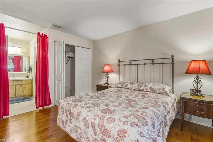 Bedroom with hardwood / wood-style flooring, a closet, and ensuite bathroom