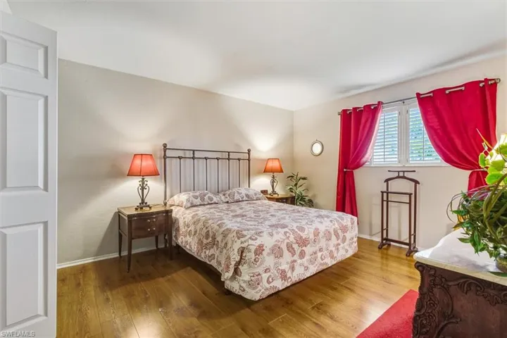 Bedroom featuring hardwood / wood-style flooring and baseboards