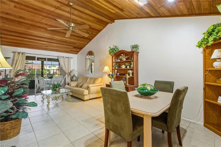 Dining room featuring wooden ceiling, a ceiling fan, vaulted ceiling, and light tile patterned floors