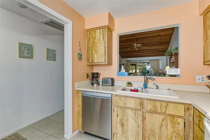 Kitchen featuring light brown cabinets, stainless steel dishwasher, and light countertops