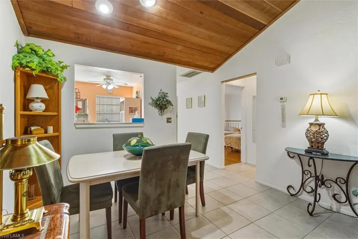 Tiled dining area featuring wood ceiling and lofted ceiling
