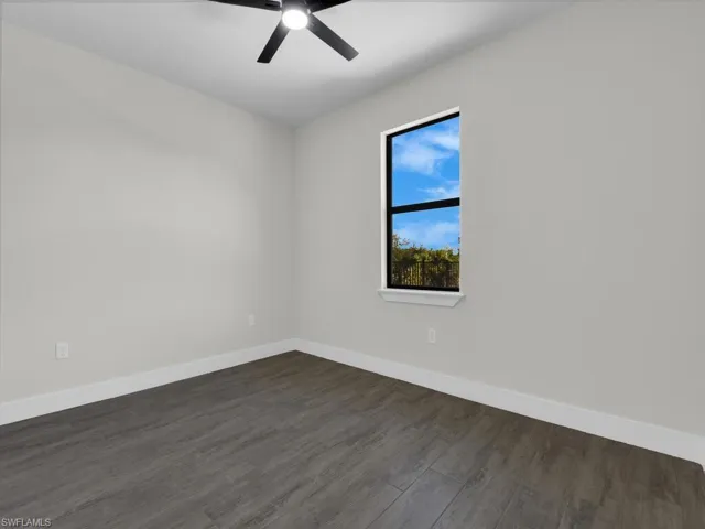 Spare room featuring dark wood finished floors and a ceiling fan